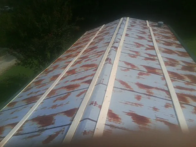 Rusted metal roof panels with new wood purlins before replacement — Storm Damage Roof Repair in Elmira by Roofing Brothers